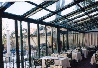 Cerramiento de cristal con puertas correderas y estructura de techo metálica para un restaurante en Alicante.